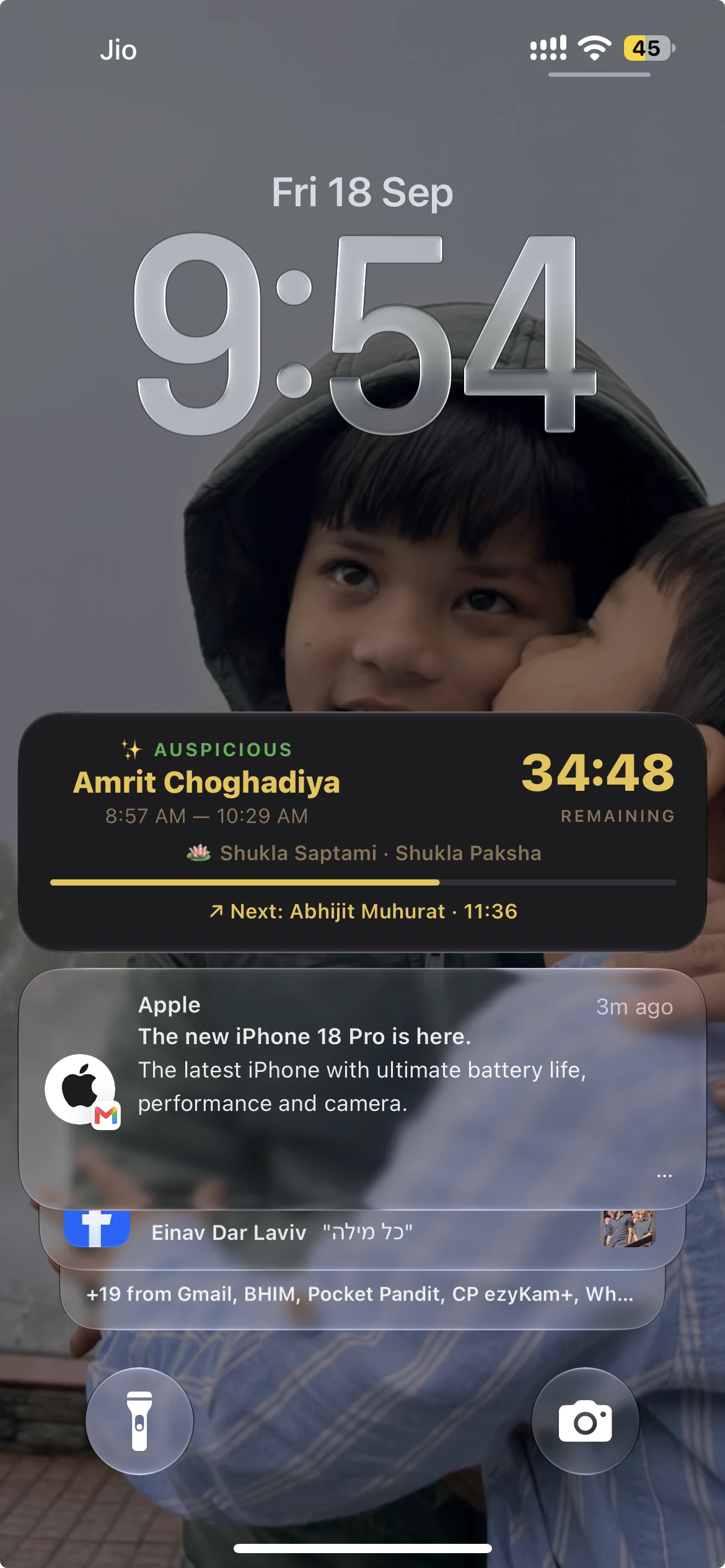 iPhone lock screen showing the Pocket Pandit Live Activity: the current Choghadiya window with its countdown and the next Muhurat